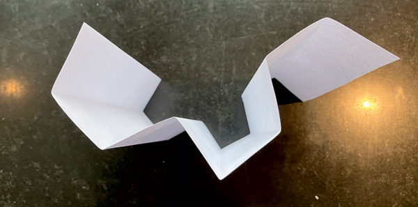 Figure 2: The unfolding of a folded piece of paper. From left to right, the sequence of valleys and peaks is shown in (1).